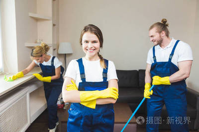 在工作過程中使用專業設備的清潔服務。專業的小廚房清潔, 沙發干洗, 窗戶和地板清洗。穿制服、工作服和橡膠手套的男人和女人